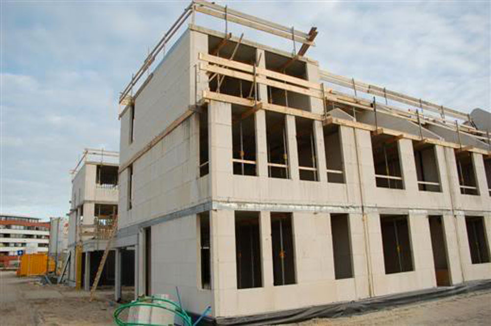 The 18 households that buy the properties in the two back-to-back terraces work together to hire one contractor to build the basic structure of their homes and the shared garage between the two terraces. This saves them money and speeds up delivery