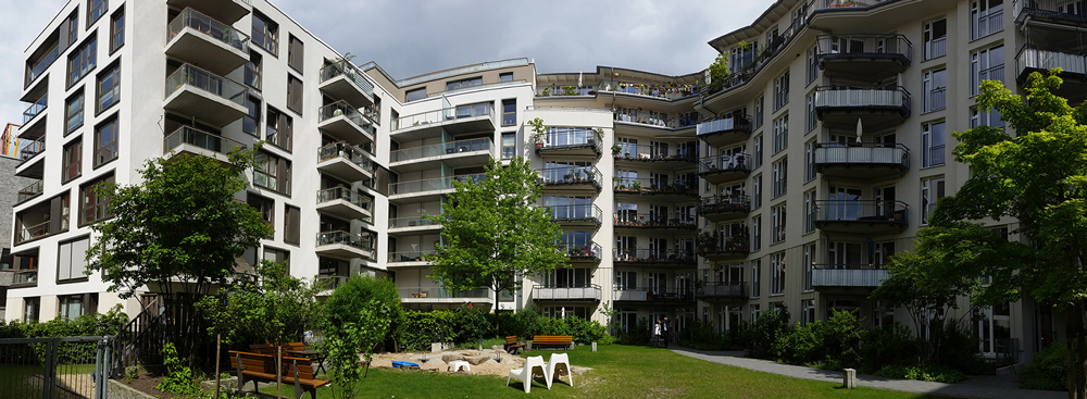 The homes are arranged around a shared podium garden, above a shared garage 
